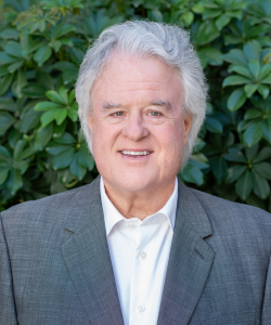 Our team member, Professional headshot of Dave Savage, founder of ACI Apartments, wearing a suit and smiling.